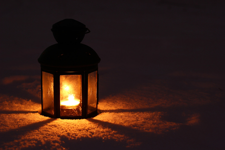 Candle lamp in snow at nightの写真素材