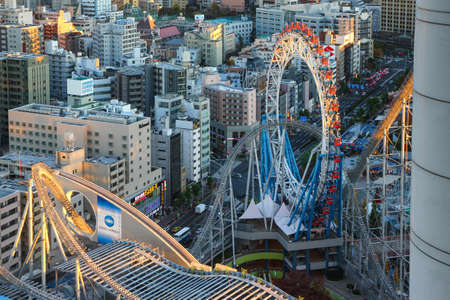 Amusement park in the center of Tokyo. Roller coaster intertwining with skyscrapers.のeditorial素材