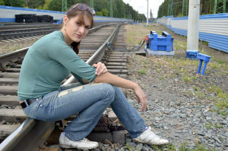 Young woman sitting on the tracksの写真素材
