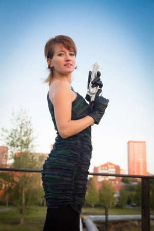 young woman in autumn park holding a gunの写真素材