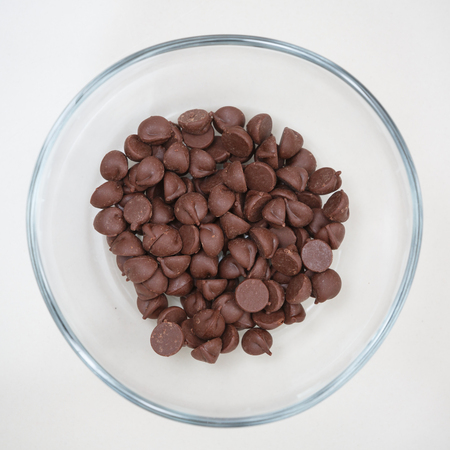 close up of chocolate chips in glass bowlの写真素材