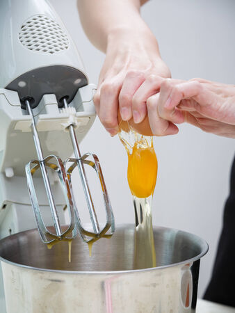 breaking egg to the mixing machineの写真素材