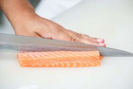 salmon is cutting on a white tableの写真素材
