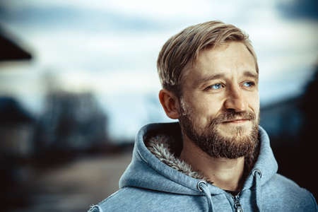 Young man with a beard and mustache outdoor portrait