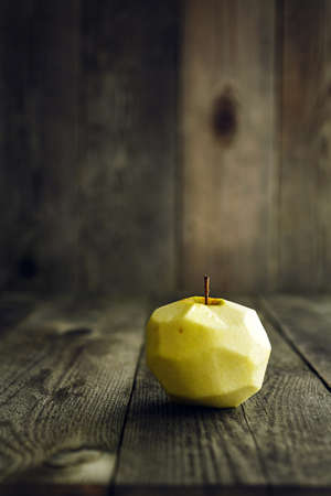 Peeled Apple on a wooden table, soft focusの写真素材