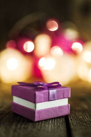 Christmas background with decorations and gift box on wooden board. Soft lights in the background.の写真素材