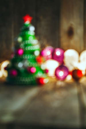 Blurry Christmas background with decorations and handmade Christmas Tree on wooden board, copy space included. Soft bokeh lights and Christmas Tree in the background. This can be used as Christmas or New Year's greeting card.の写真素材