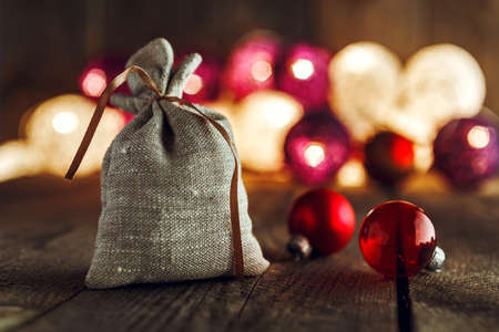 Christmas background with decorations and gift bag on wooden board. Soft lights in the background.の写真素材