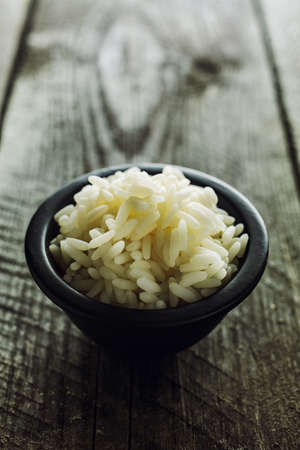 Plain boiled rice in small bowl on a wooden backgroundの写真素材