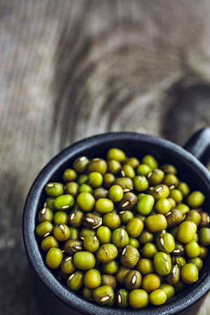 Close-up of green organic mung beans on a wooden backgroundの写真素材