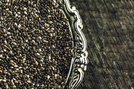 Super healthy chia seeds in silver plate on wooden backgroundの写真素材