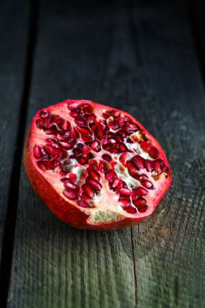 Ripe pomegranate fruit on wooden vintage backgroundの写真素材
