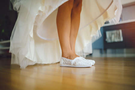 Details of the wedding day. Wedding dress and white sneakersの写真素材