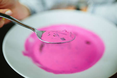 Cold beetroot soup. Focus on spoon. Fine film grain texture.の写真素材