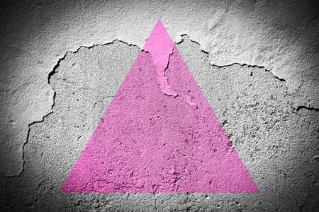 Pink triangle flag painted on grungy cracked wallの写真素材