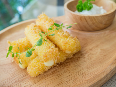 fried cheese stick on a wooden pateの写真素材