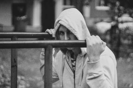 fitness, sport, exercising, training and lifestyle concept - young man doing triceps dip on parallel bars outdoorsの写真素材