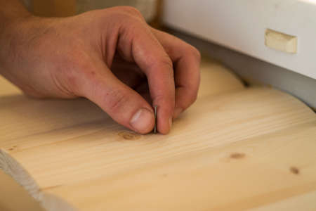 Hammer and Nail Using hammer and nail on wood and bokeh backgroundの写真素材