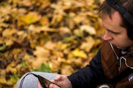 Young man listening to music on smartphone on the natureの写真素材