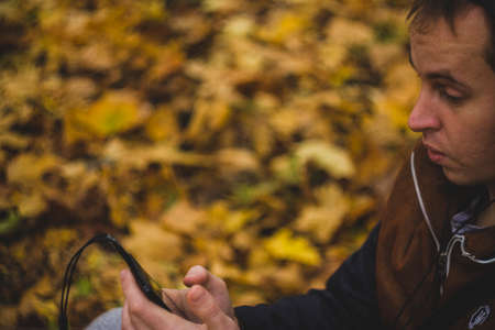 Young man listening to music on smartphone on the natureの写真素材