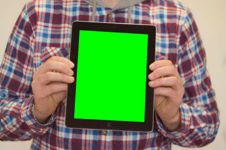 young man holding tablet with green screenの写真素材