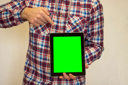 young man holding tablet with green screenの写真素材