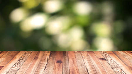 Perspective wood and bokeh light background. product display template. Wood table top on blur moving natural green leaf background.の写真素材