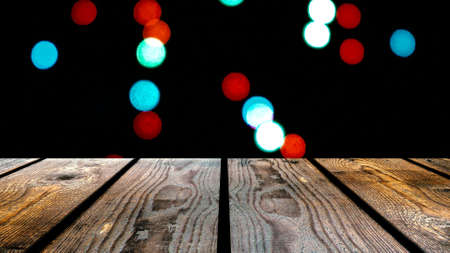 Perspective wood and bokeh background of night and the shimmering glare of the lights. display template item.の写真素材