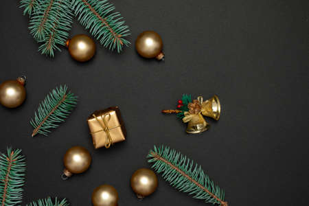 Christmas decoration with  fir tree and golden Christmas baubles on a dark background. Flat lay. Nature New Year concept.の写真素材