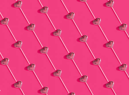 Valentines Day bckground. Lollipop candy hearts on orange background. Flatlay minimal concept.の写真素材