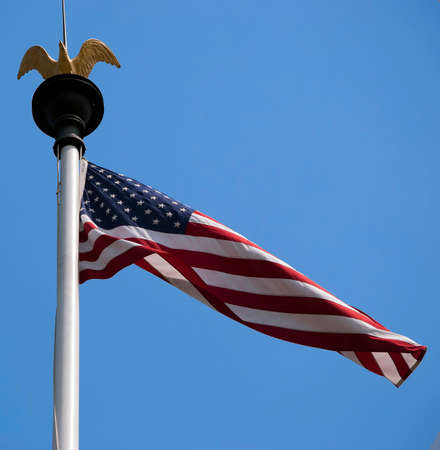 American flag waving in the wind on the blue sky