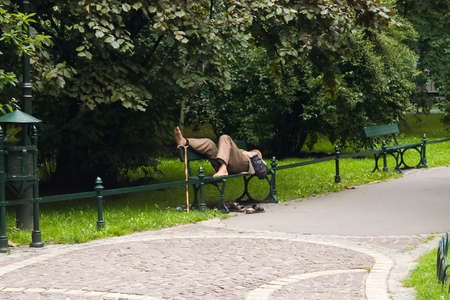 Old man is relaxing in park with his rod near his feetの写真素材