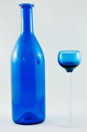 Blue cherry brandy bottle and a single blue glass.の写真素材