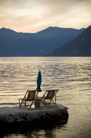 Two chairs, with umbrella in sunset