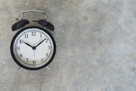 Vintage black alarm clock Placed on the cement floor, top view