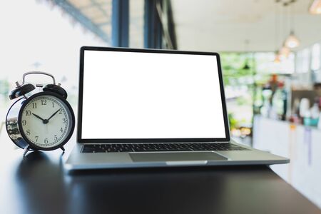 Laptop mockup and vintage black alarm clock On the table in the coffee shop