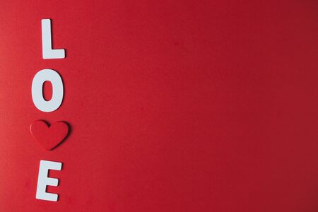 White wooden letters and red wooden hearts on a red backgroundの写真素材