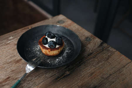 Close up view of blueberry cheesecake on a wooden table in a coffee shopの写真素材
