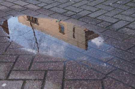 Reflection of a house in a puddle