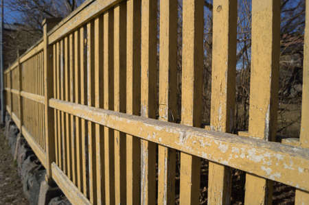 A exfoliated yellow wooden fenceの写真素材
