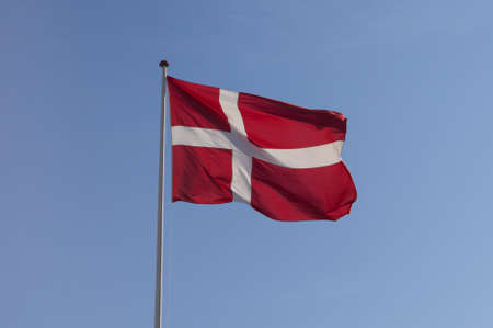 a waving Danish flag before a clear skyの写真素材