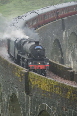 The jacobite steam train drives over the Glenfinnen viaduct in Scotland