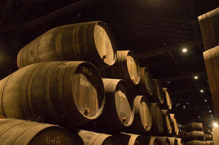A row of barrels filled with port wine in a cellar in Portoの写真素材