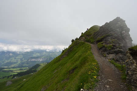 Hiking path panorama on a misty mountain trail in Switzerland.の写真素材