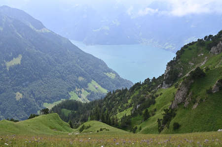Blue lake with surrounded by mountains peaks in the background.の写真素材