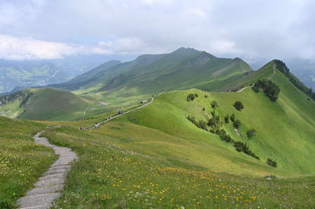 A hiking mountain trail with climbing stairs on a ridge mountains in Switzerland.の写真素材