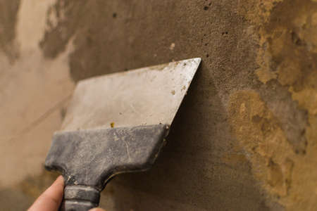 repair the old walls with a spatula preparation for the repair of the old house