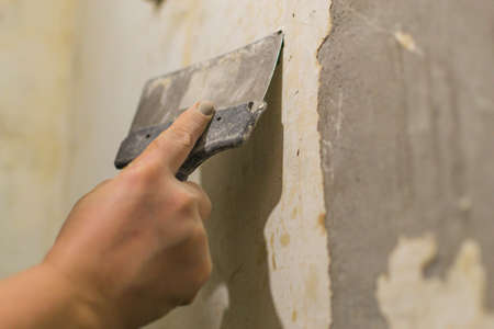repair the old walls with a spatula preparation for the repair of the old house