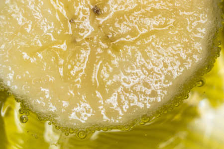 banana in water close-up on yellow bubbles background