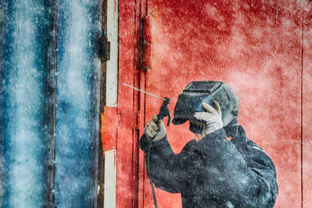 welding a man repairs a garage outdoorsの写真素材